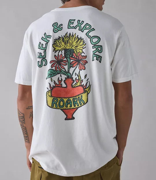 Person wearing a white t-shirt with a colorful graphic and text on the back, standing against a plain background.