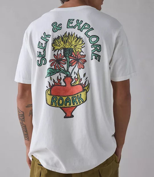 Person wearing a white t-shirt with a colorful graphic and text on the back, standing against a plain background.