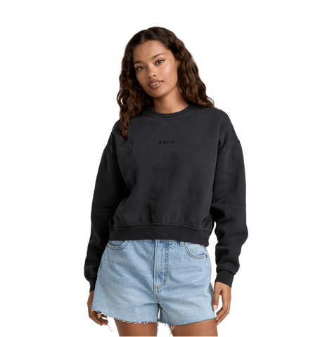 Woman wearing a black sweatshirt and denim shorts on a white background