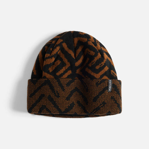 Brown and black patterned beanie on a light gray background
